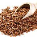 Flax seeds in wooden scoop, whole brown seeds