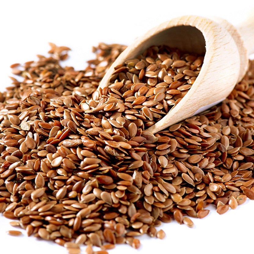 Flax seeds in wooden scoop, whole brown seeds