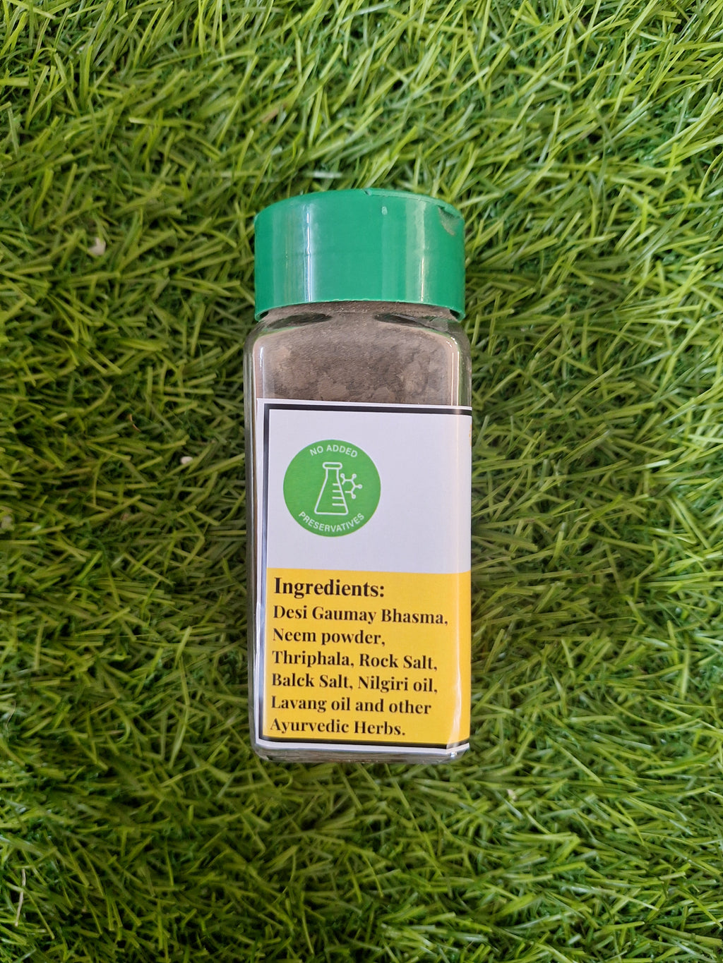 Tooth powder bottle with green cap, ingredients panel and Bheeshma branding