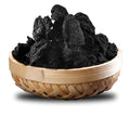 Dried dark tamarind fruits in woven wooden basket