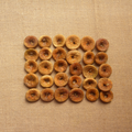 Dried fig slices, round golden-brown pieces arranged on textured fabric