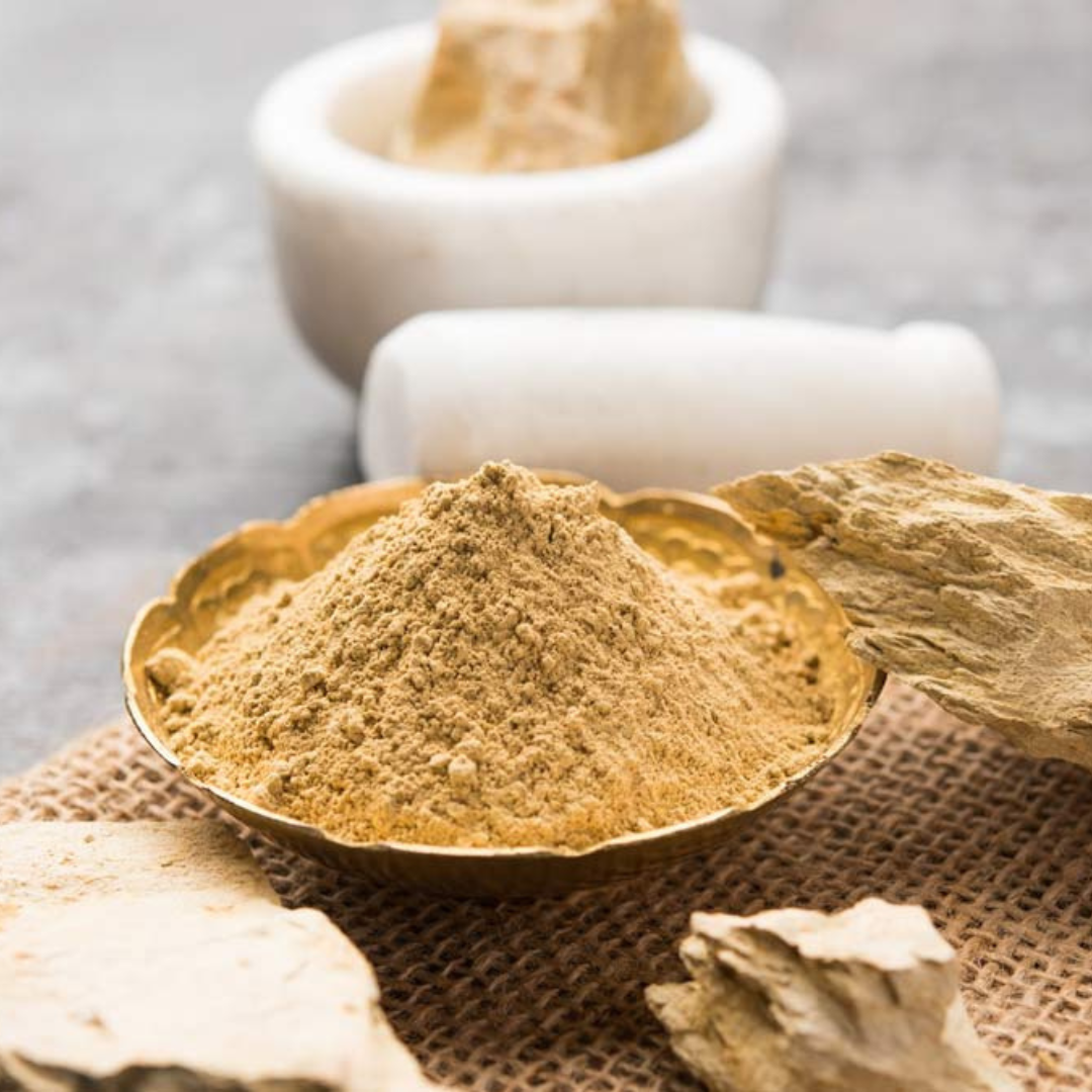 Multani mitti powder in a small bowl, light brown loose powder granules