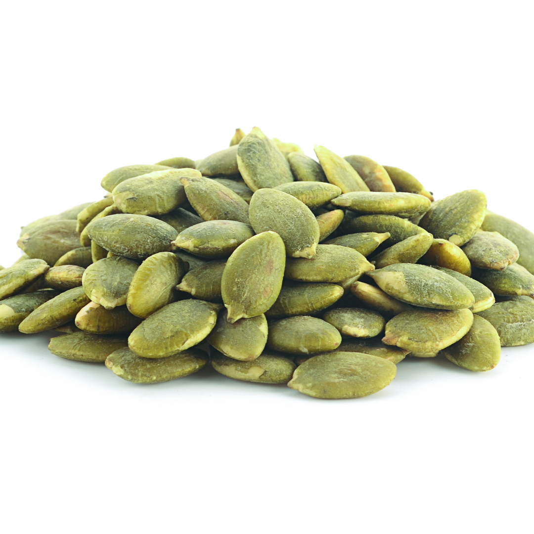 Raw green pumpkin seed kernels piled on a white background