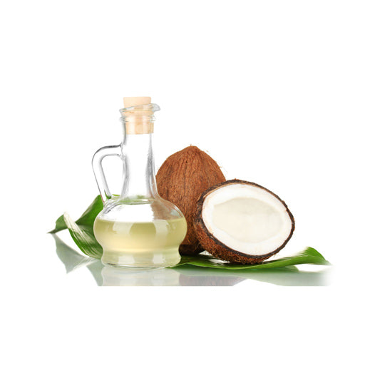 Glass bottle of coconut (kopra) oil with green leaves and a halved coconut