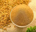 Fenugreek/menthi powder, fine brown spice powder in a white bowl
