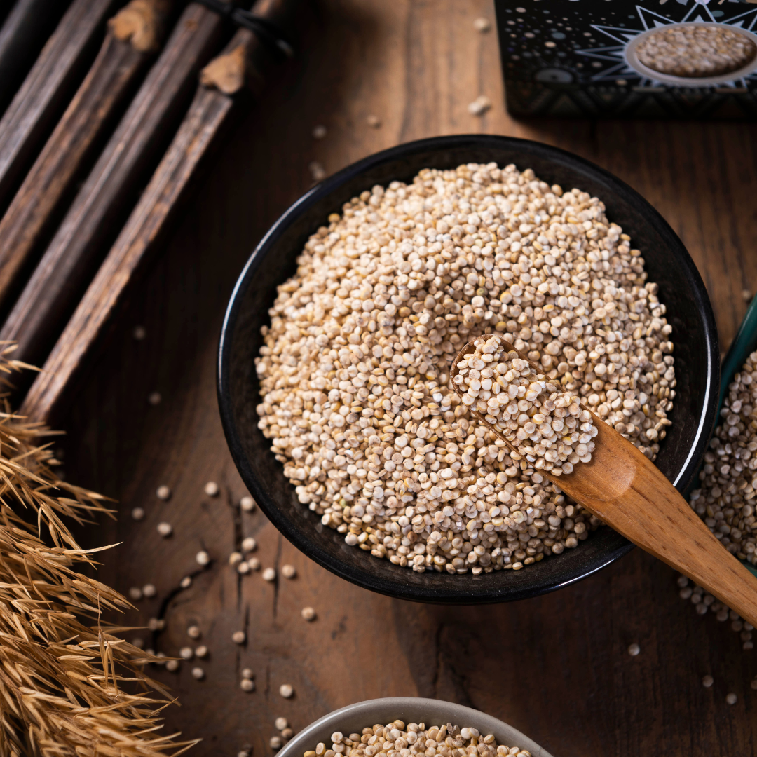 Bowl of quinoa seeds with wooden spoon