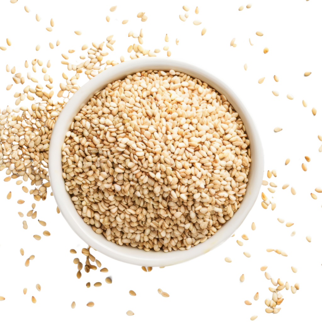 White sesame seeds in a white bowl, scattered around.