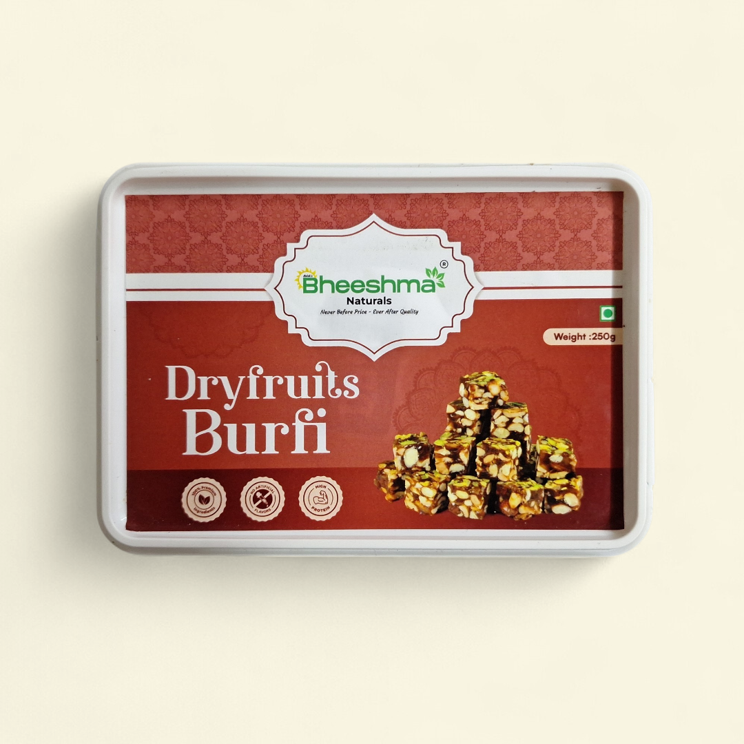 Dry fruits burfi sweet in rectangular tray, gold nut pieces on dark red pack.